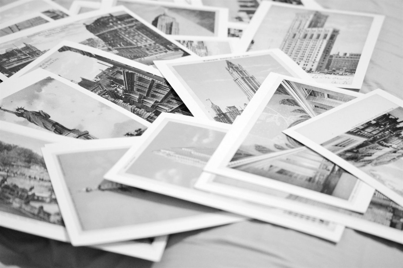 A pile of vintage picture postcards spread across a table